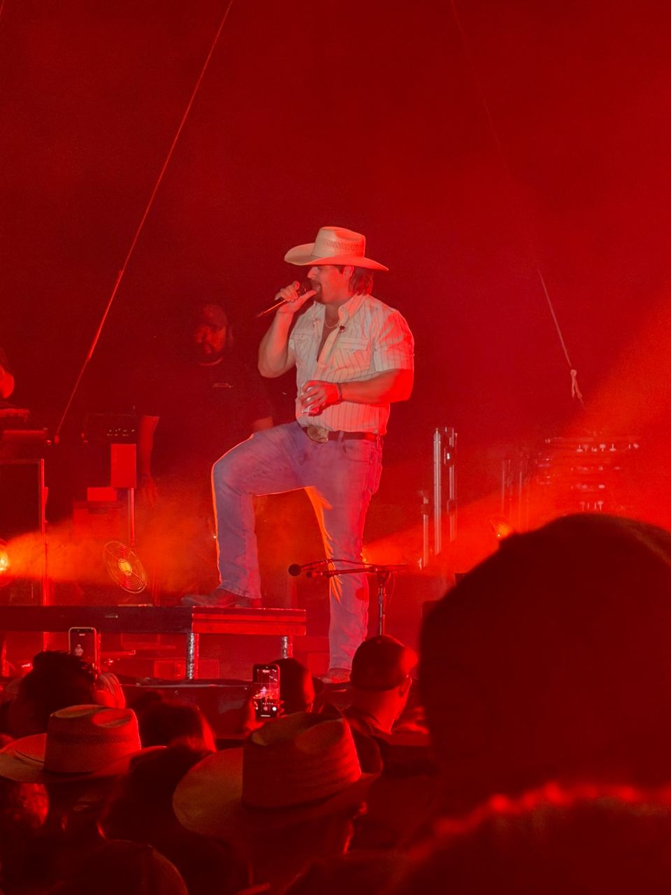 Gavin Adcock performing on a stage lit red