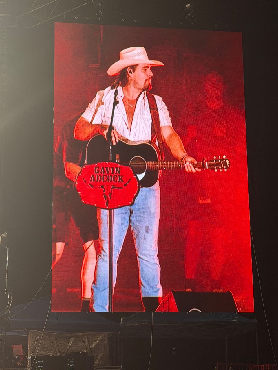 Venue screen showing Gavin Adcock playing acoustic guitar