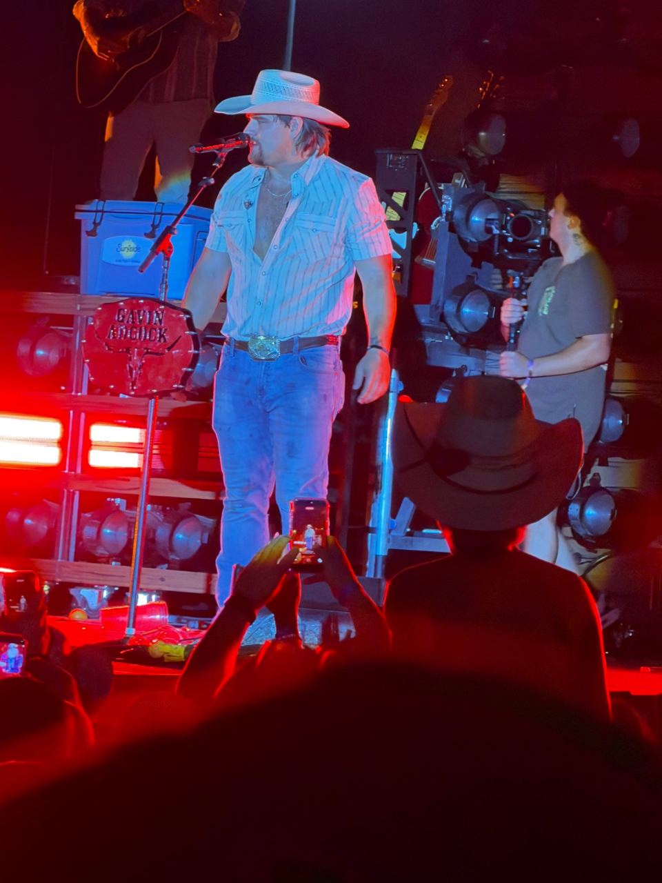 Gavin Adcock singing in front of the drum kit under red and blue lights