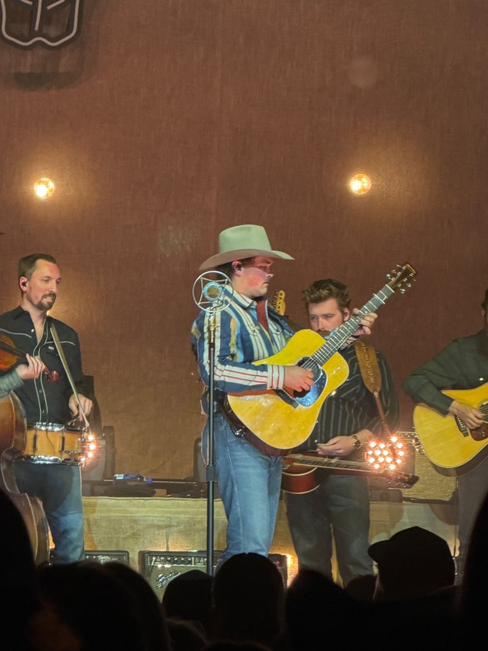 Zach Top performing with an acoustic guitar alongside his band